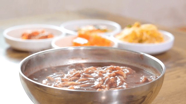 Bowl of Korean red bean noodle with side dishes