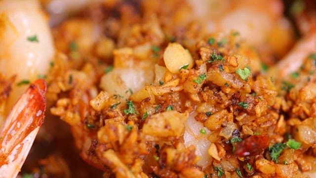Appetizing gambas topped with garlic flakes and herbs