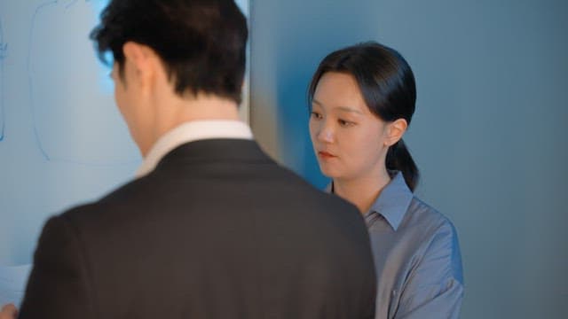 Two colleagues discussing at a whiteboard