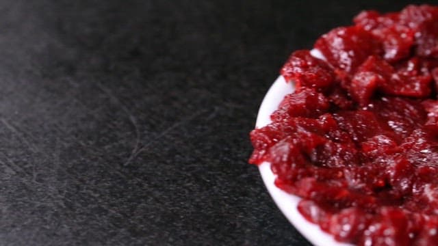 Freshly sliced raw bottom round steak on a white plate