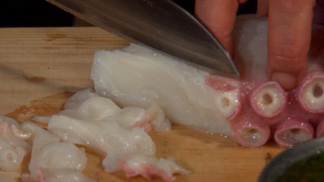 Slicing Octopus on Wooden Cutting Board