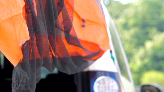 Orange and black fabric hanging from a vehicle