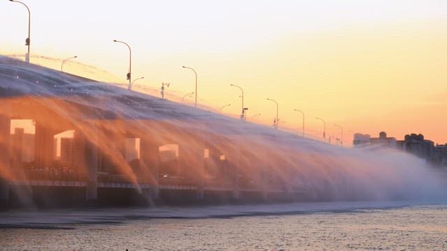 Water fountain on a bridge during sunset