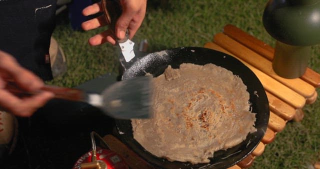 Preparing Vegetable Pancakes Outdoors at Night during Camping