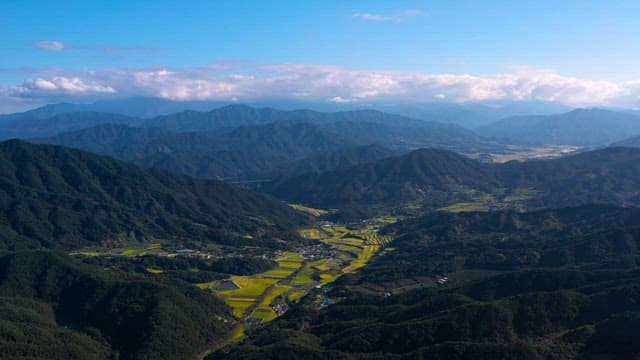 Lush Green Mountain Valleys with Yellow Rice Fields