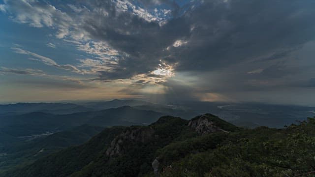 Changes in the Sky Above the Majestic Mountains from Day to Evening