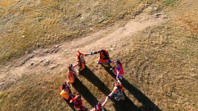 People in traditional attire dancing in a circle