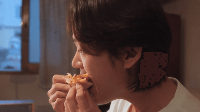 Person enjoying a slice of pizza indoors