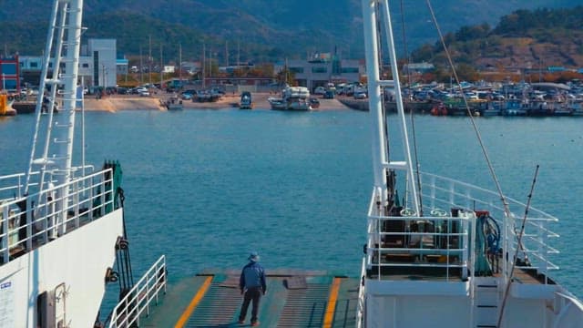 Man standing on ferry deck overseeing harbor