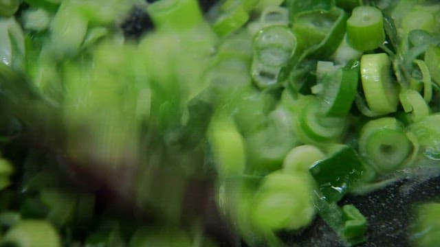Frying butter and chopped green onions in a frying pan
