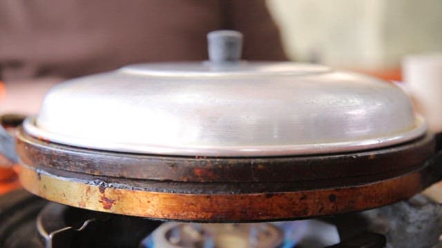 Octopus cooking under a lid on a stove