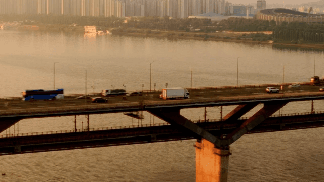 Cars crossing a bridge at sunset