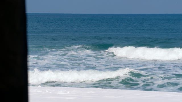 Seaside view on a clear day with waves hitting the shore