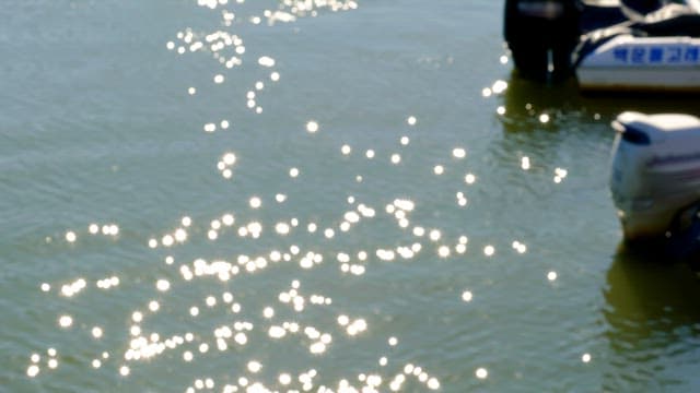 Sunlight reflecting and sparkling on calm water surface