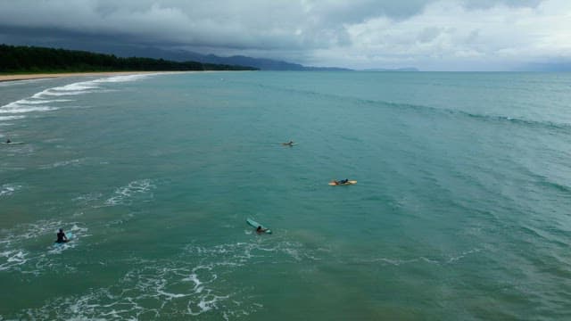 Surfers paddling in the ocean near the shore