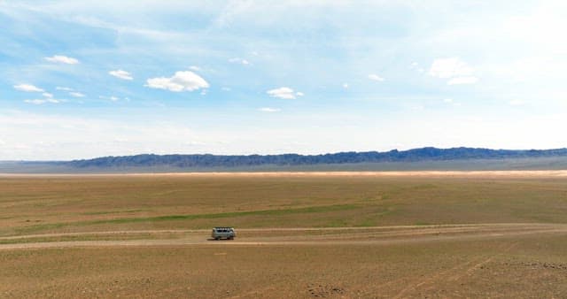 Vans driving through a vast desert landscape