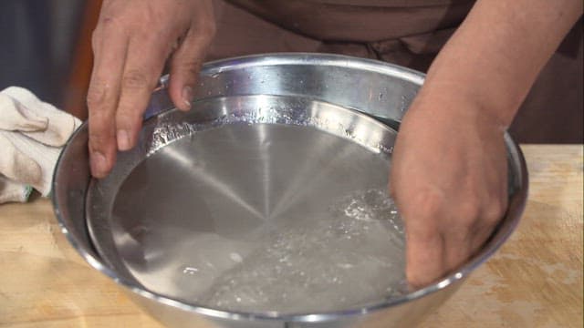 Chef removing cooked starch batter from a tray