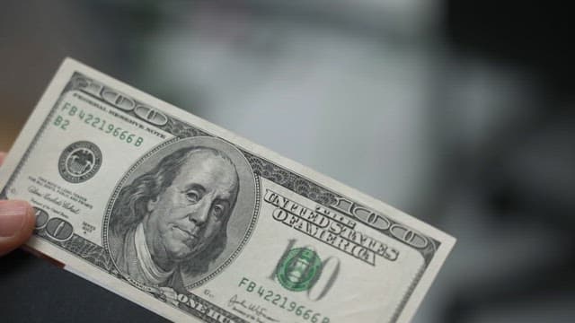 Person holding a hundred-dollar bill