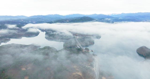 Misty Lakeside Road Amidst Mountain Range