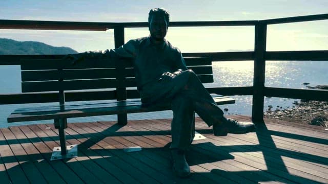 Man Statue Sitting Alone on a Bench by the Sea