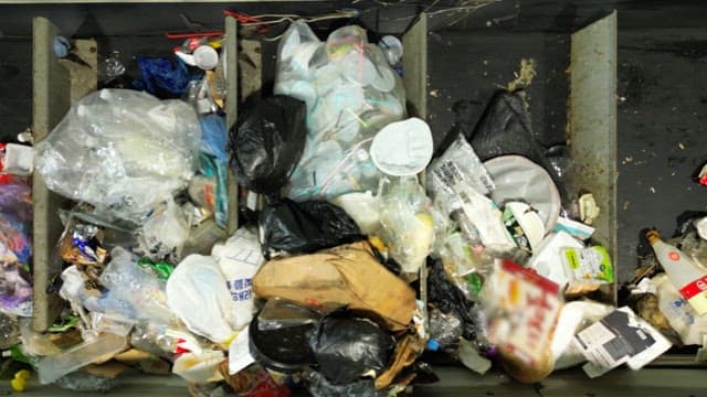 Conveyor belt transporting various waste materials indoors