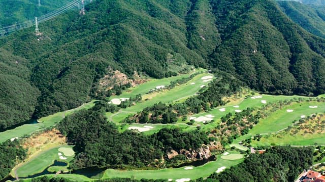 Peaceful Golf Course at the Foot of a Green Mountain