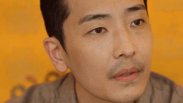 Man having a conversation in front of a yellow wall