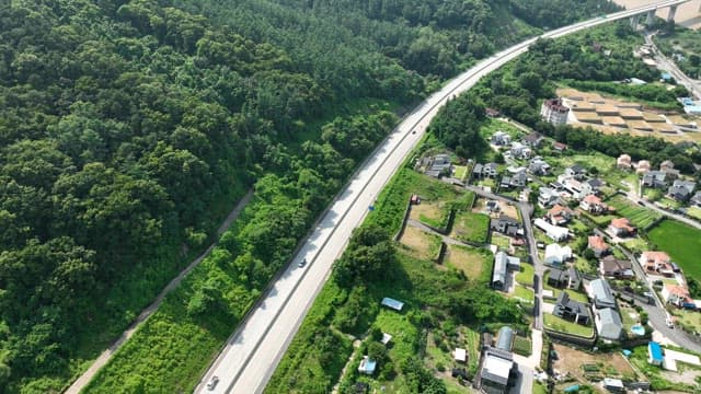 Highway Between Lush Green Space and Residential Areas