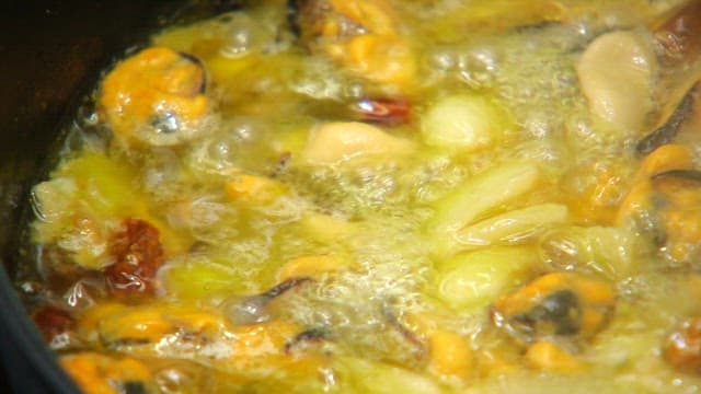 Mussels and garlic sizzling in oil