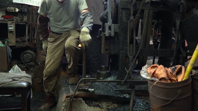 Worker handling metal in a factory