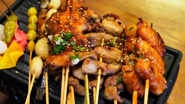 Various types of grilled skewers neatly arranged on an iron plate