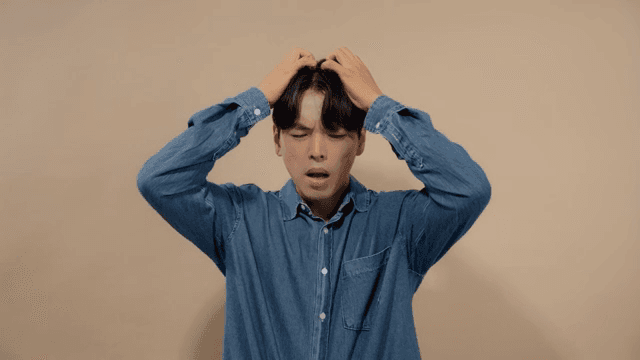 Man in agony and despair, holding his head with his hands