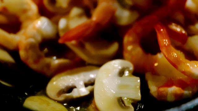 Shrimp and mushrooms cooking in a pan