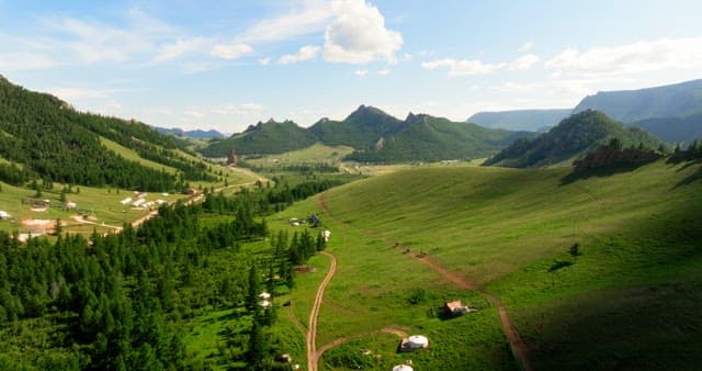 Expansive green valley with distant mountains