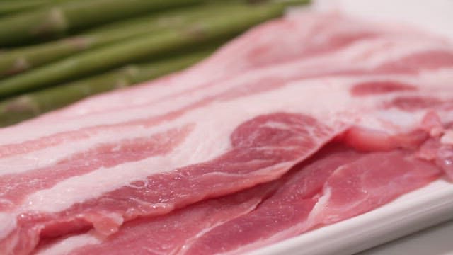 Fresh Thin-sliced Pork Belly and Asparagus on a White Plate