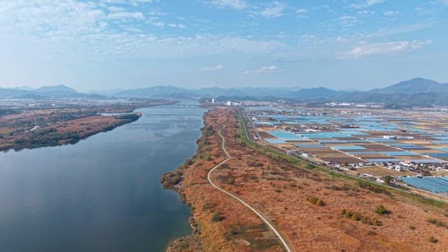 Serene river flowing beside farmland and mountains