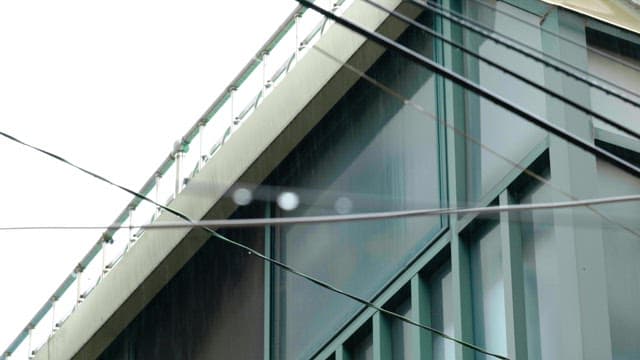 Nearby a building on rainy day with wires