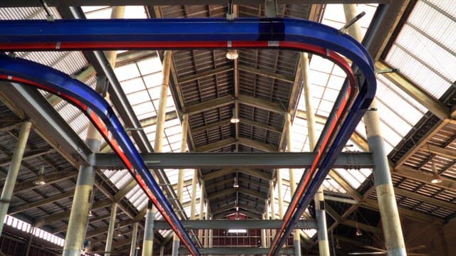 Metal structure barn with milk cows eating hay