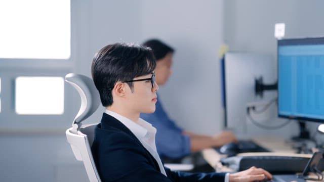 Man wearing glasses smiling while working in the office