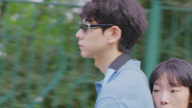 Two people, riding a bike outdoors on a sunny day