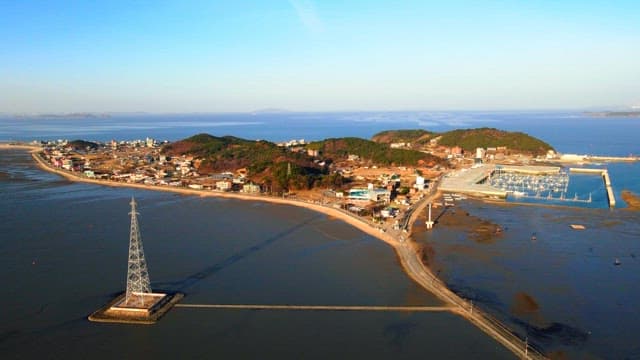 Island surrounded by the sea and hills with a view of the transmission towers