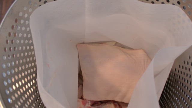 Oriental medicine ingredients placed in a fabric strainer inside a metal container