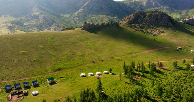 Scenic view of yurts in a green valley