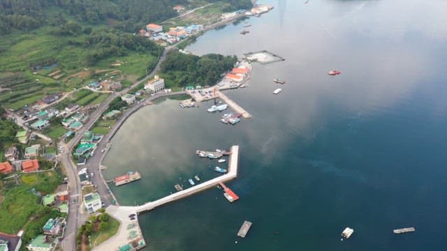Farming and fishing village with docks and boats in calm water