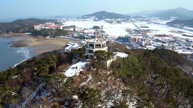 Snow-covered observation tower overlooking a seaside town
