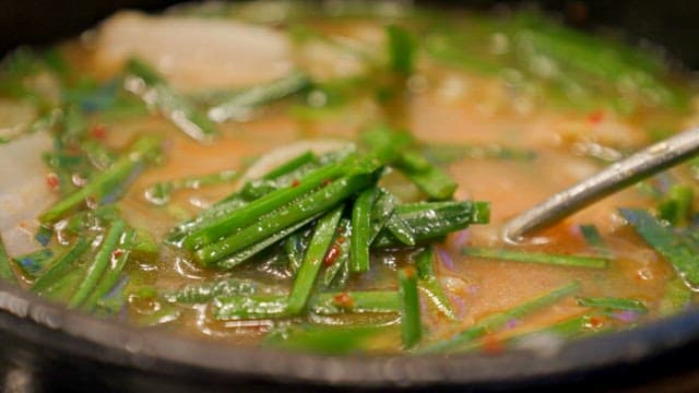 Hot pork and rice soup with lots of chives
