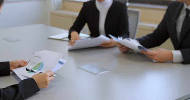 Professionals Discussing Reports at Meeting