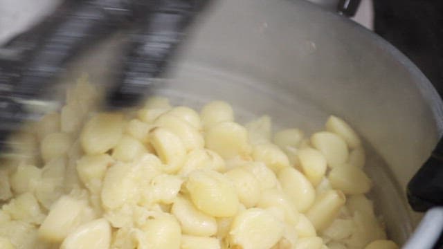 Boiled Garlics Being Mashed in a Pot