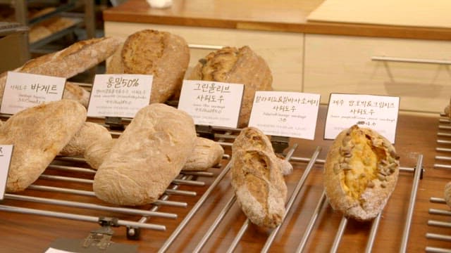 Various types of artisanal sourdough bread displayed in a bakery