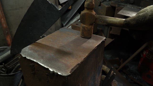 Hammering a metal blade on an anvil